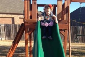 Kennedale, Texas, slides - swing set accessories, cute little girl sliding down a green slide on redwood playset