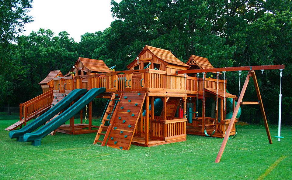 A picture of a couple of Backyard Fun Factory Fort Stockton Redwood Playsets bridged to a Mustang Redwood Playset