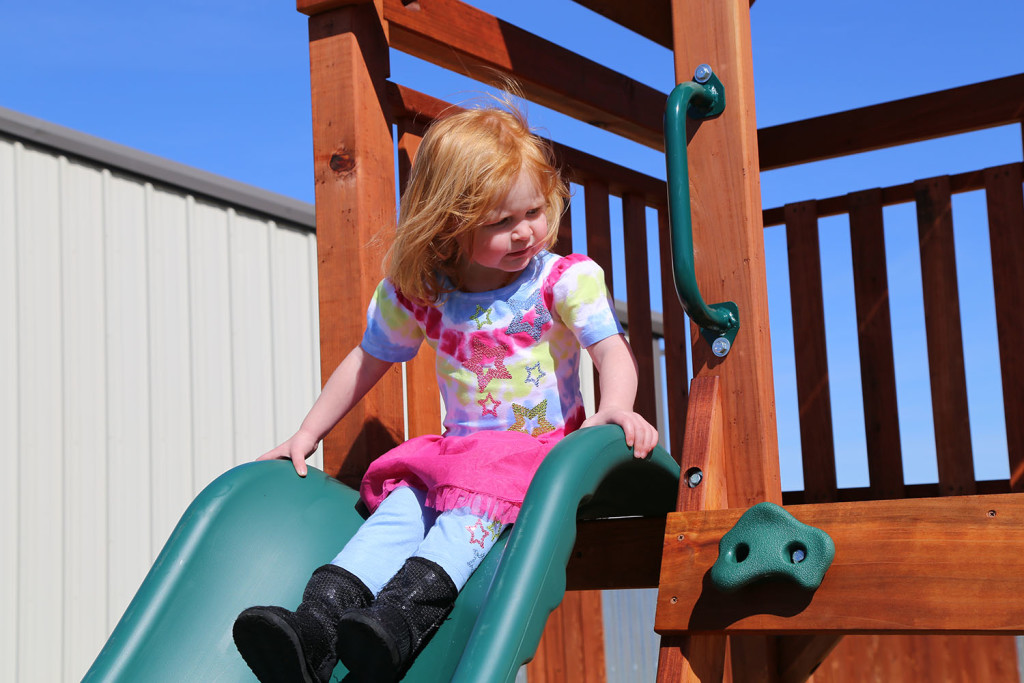 lake charles, louisiana, accessories - girl sliding down slip wearing pink dress and black boots