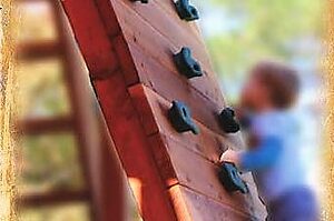 rock wall climber made of redwood lumber and plastic climbing rocks for kids backyard swingsets