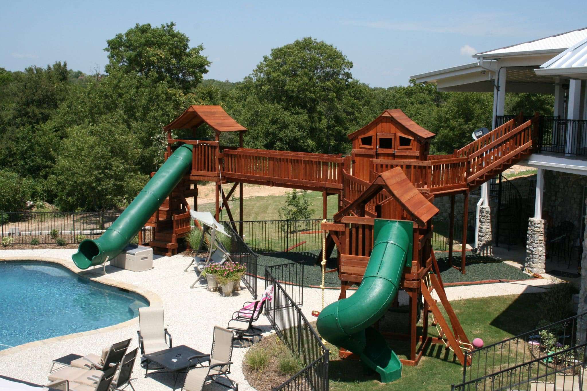 financing, playset bridged to second balcony of home with slides going into pool
