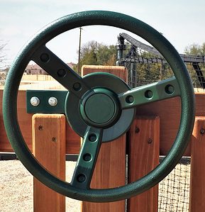 kids toy green steering wheel is attached to a redwood swing set