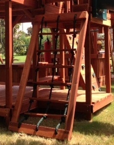 kids cargo net with rope, redwood inserts and a redwood frame attached to a backyard wooden swing set