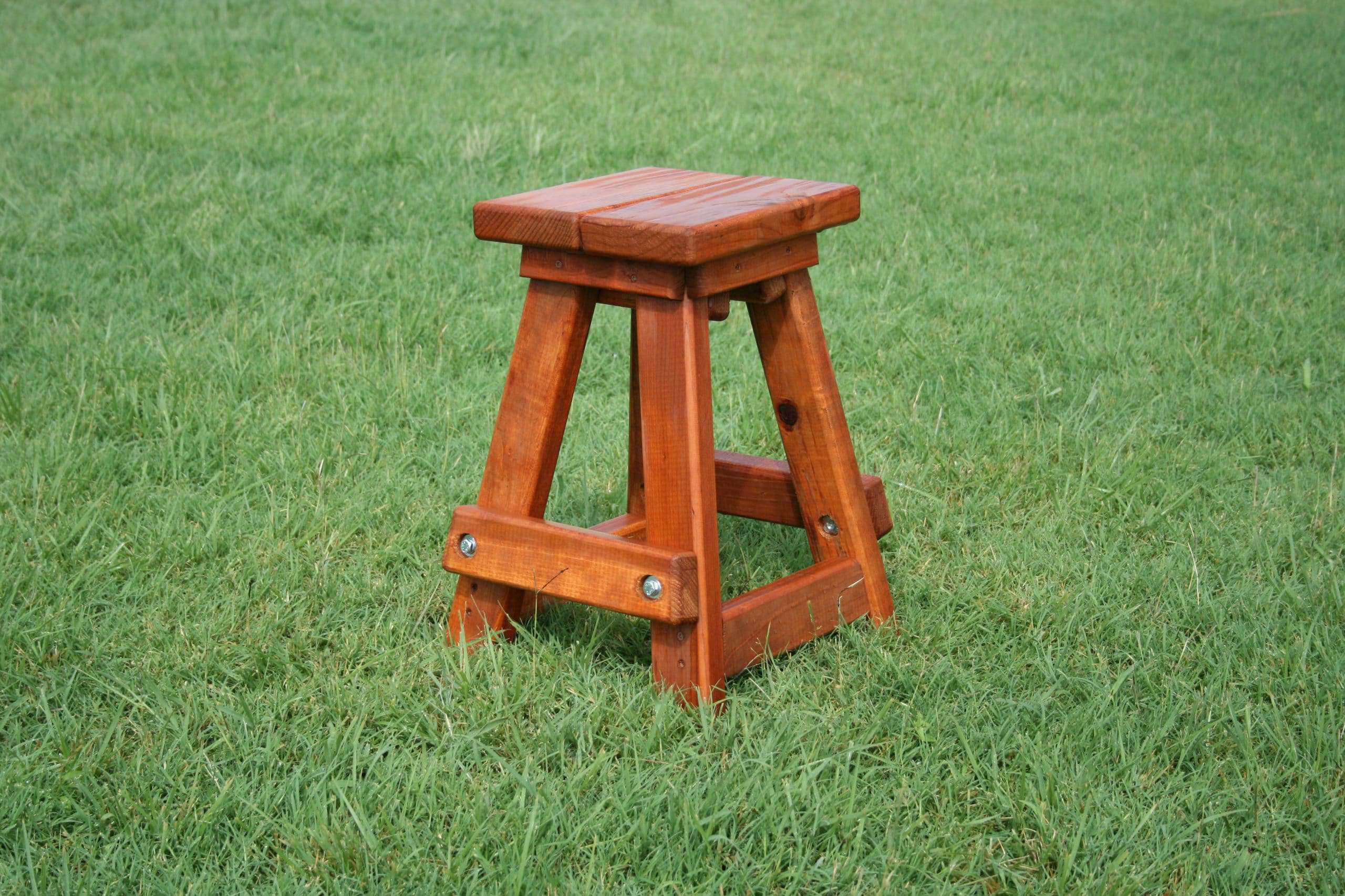 kids redwood stool is sitting on green grass
