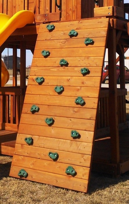 redwood rock wall with green climbing rocks on wooden swing in dallas