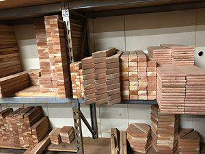 Raw redwood lumber materials for building custom swing sets and outdoor play structures in our swing set factory in Justin, Texas