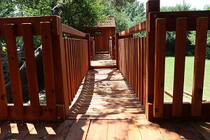 Safety rails help to keep kids going on a Backyard Fun Factory playset. coppell texas, bridge connecting playsets in backyard, redwood bridge, kids bridged swingset