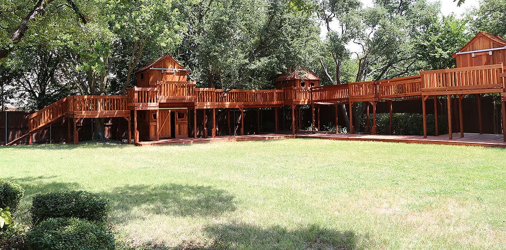 huge custom redwood set with bridges, forts, cabins, ramps, walkways, and tree decks in this backyard