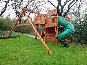 fort with tree deck, wooden playset customized around a backyard tree with swing set accessories, cabin and slides