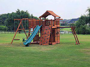 Montgomery, Texas, fort stockton with overhead climber swing set with upper wrap around deck, lower cabin rock wall
