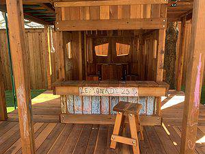 Children decorating their Backyard Fun Factory playset's Lemonade Stand with chalk.