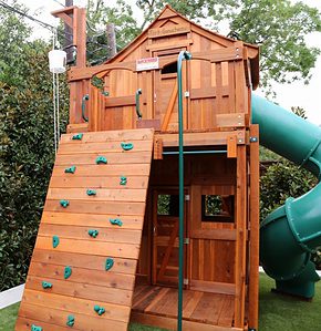 fort stockton playset with spiral slide, rock wall and fireman's pole in small space