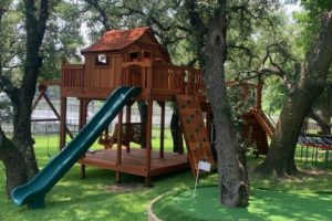 redwood fort with bridge on slope in backyard