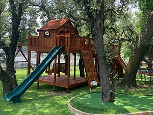redwood fort with bridge on slope in backyard