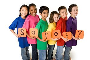 kids holding letters that spell safety - playset safety features