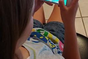 young girl playing minecraft on her phone