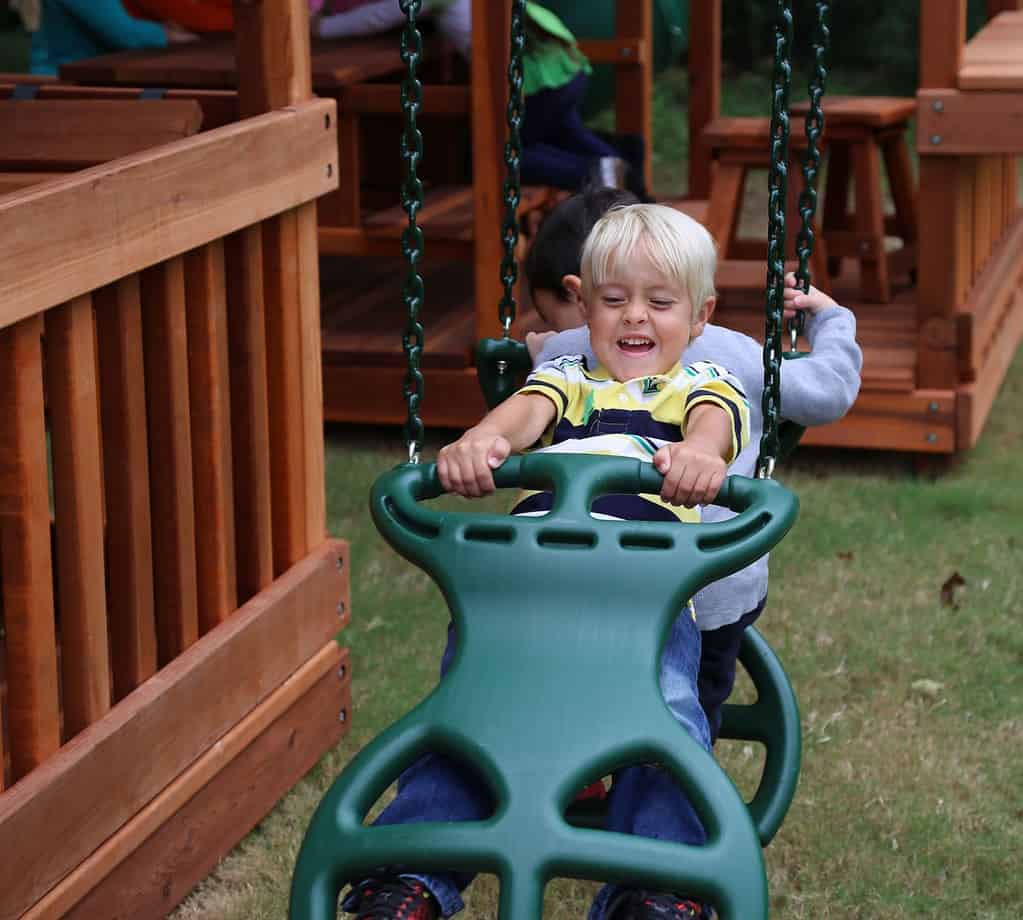 Haslet, texas, two boys on glider swing on backyard playset