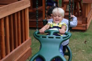 Haslet, texas, two boys on glider swing on backyard playset