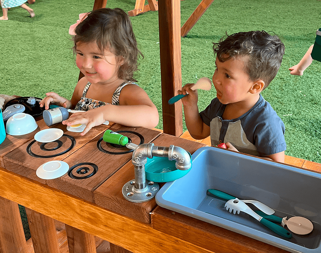 grapevine, texas, boy and girl playing on mud kitchen in lower level of fort davis playset