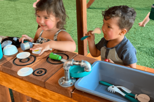 grapevine, texas, boy and girl playing on mud kitchen in lower level of fort davis playset