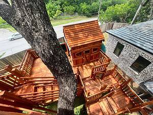 aledo, redwood playset bridged to tree house with many different levels, working with a large tree