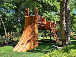 warp wall play accessory bridged to open deck with swings and climbers