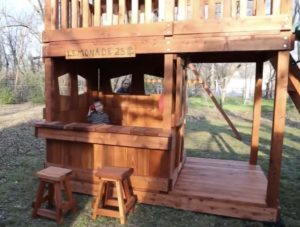 redwood playset with built in lemonade counter, fun deck, slide, ladder and swings for amazing love family