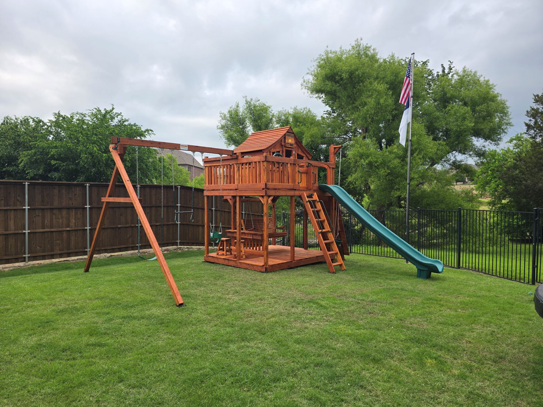 Denton, texas, Fort stockton playset, adult porch swing, green open slide, swings, upper cabin on beautiful lush green grass