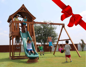 Children joyfully playing on a Backyard Fun Factory Playset with a red bow in the corner.