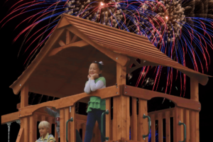 Kids enjoying the fireworks while playing on their playset. Kids ringing in the new year on their Backyard Fun Factory playset.