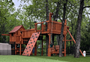 Backyard Fun Factory playset customized to nestle among trees, featuring a climbing wall, elevated deck, bridge, rock wall and adult swing. A great place to get some sun and fresh air for the New Year.
