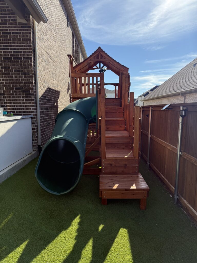 Custom backyard Toddler playset tucked into a side yard in a small backyard.