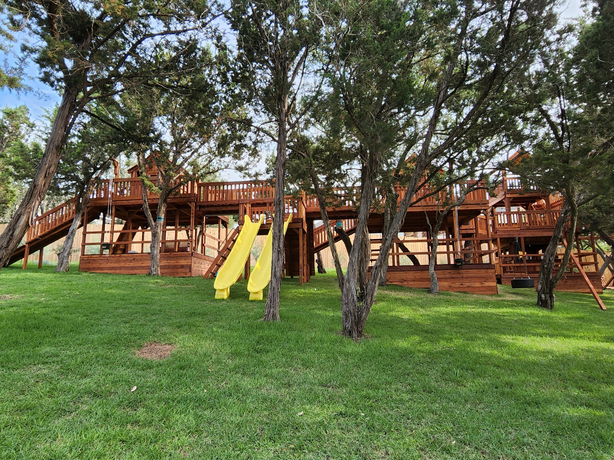 Massive redwood swing set with bridges, slides. climbers and several forts.