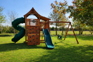 An incredible Backyard Fun Factory playset set upon a beautiful backyard lawn. swing set Flower Mound, maverick swing set spiral slide redwood fort with 5 foot and 6 foot deck